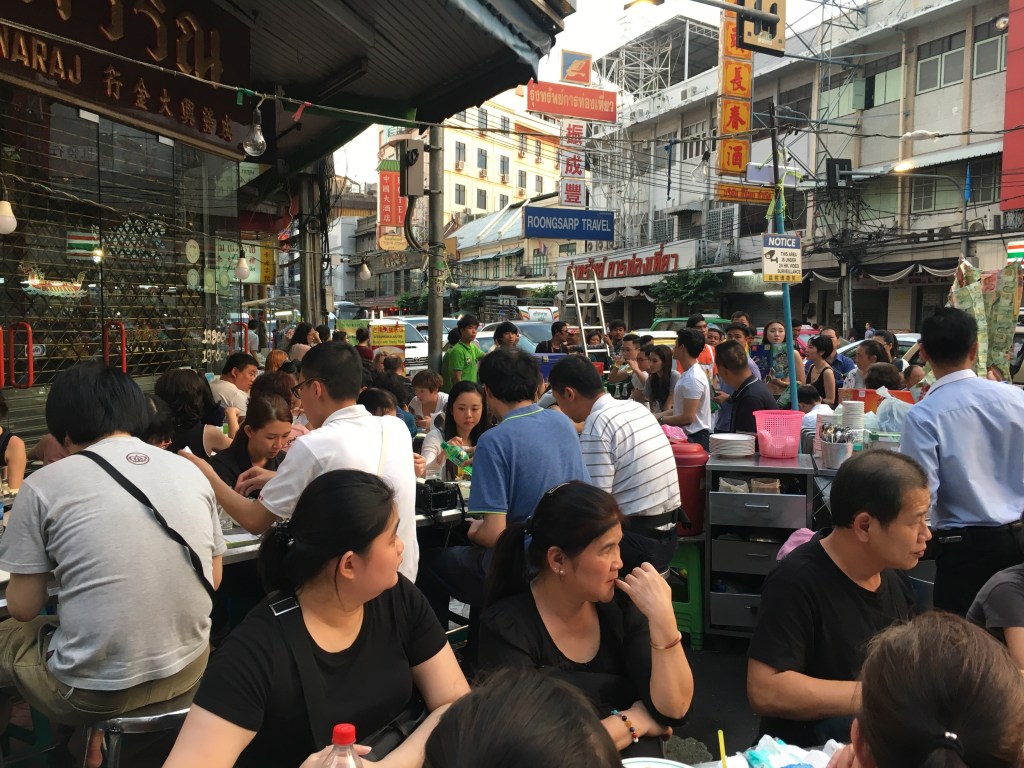 People eating and lining up for a seat at this popular seafood restaurant in Chinatown, Bangkok